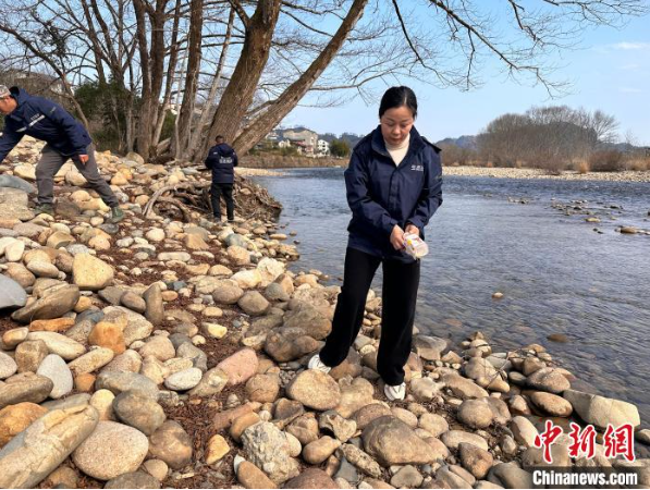 玉龍環保：王麗(前1)組織網格員巡查河道，發現垃圾同步清理